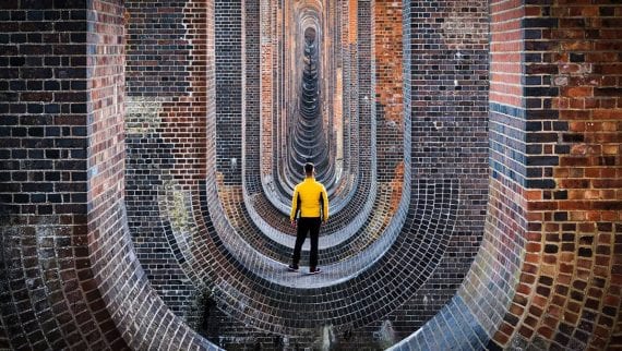 Man standing looking down a long tunnel