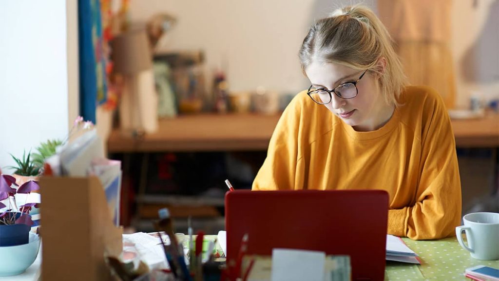 graduate application cover letter A young woman sitting at her desk looking at her laptop