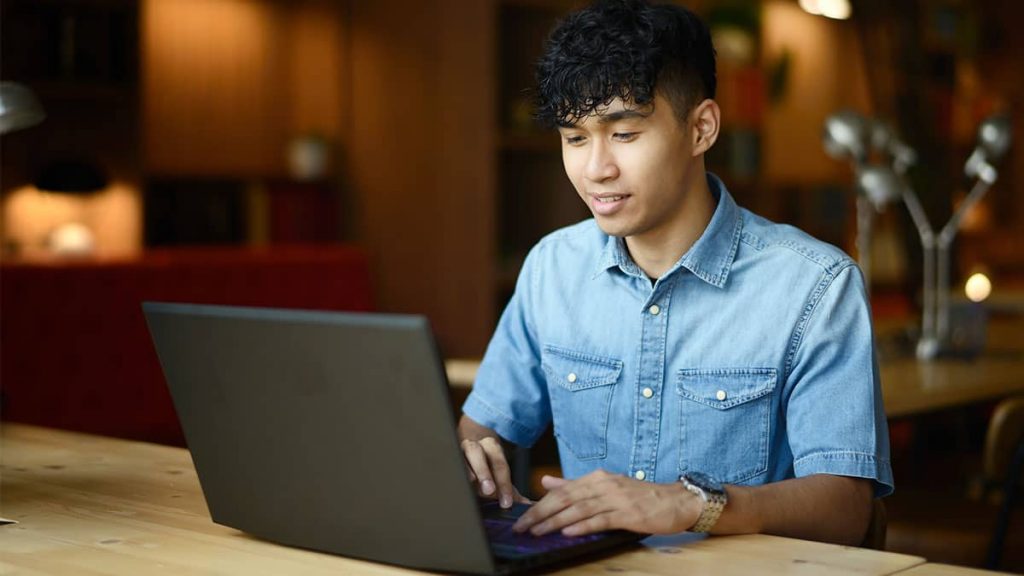 graduate application cover letter A young man working on a laptop at a table