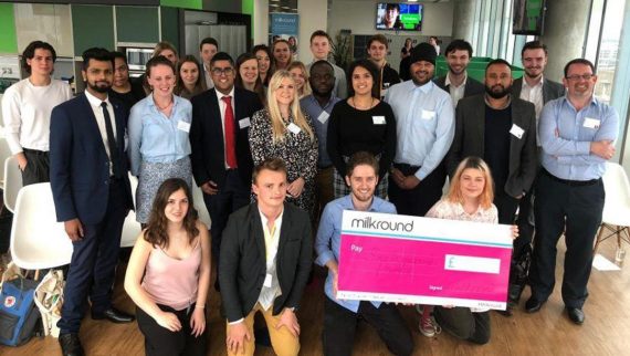 A group of young people holding a large cheque.