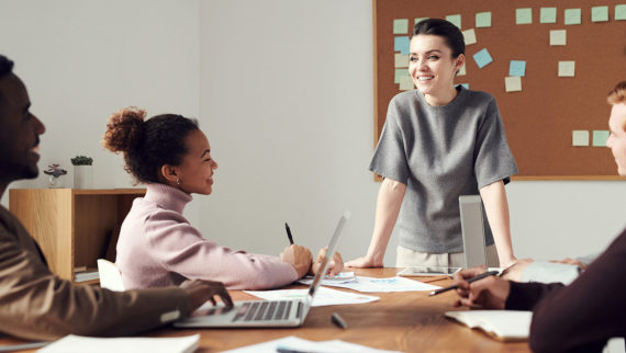 Graduates in a meeting with their manager smiling and listening