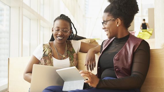 Two females talking and smiling.